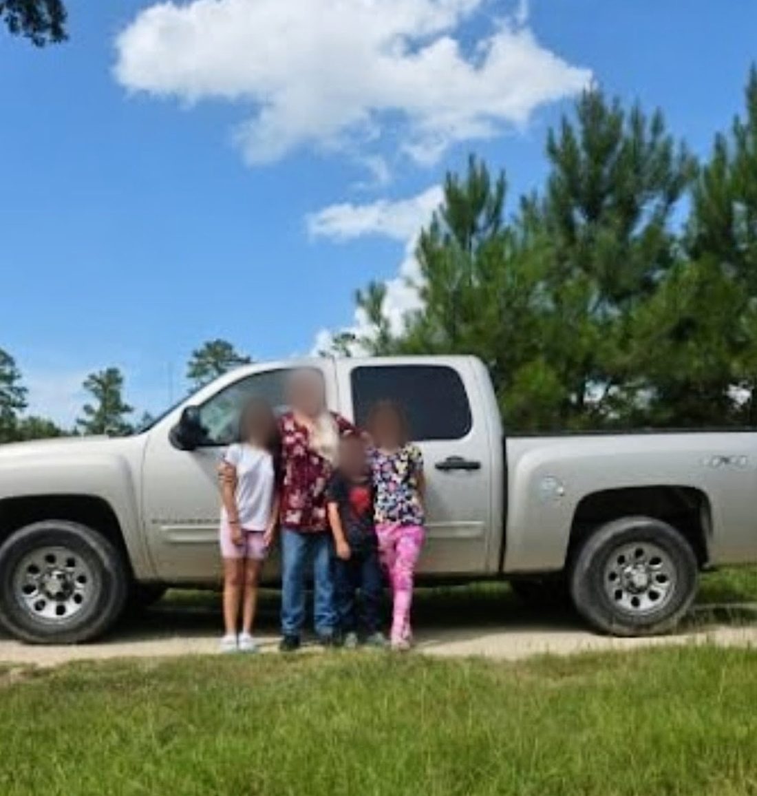 A family standing together beside the pickup truck they received through the Automobile Program