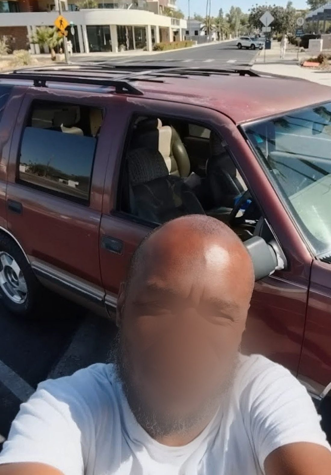 A recipient standing beside the SUV he received through the Automobile Program